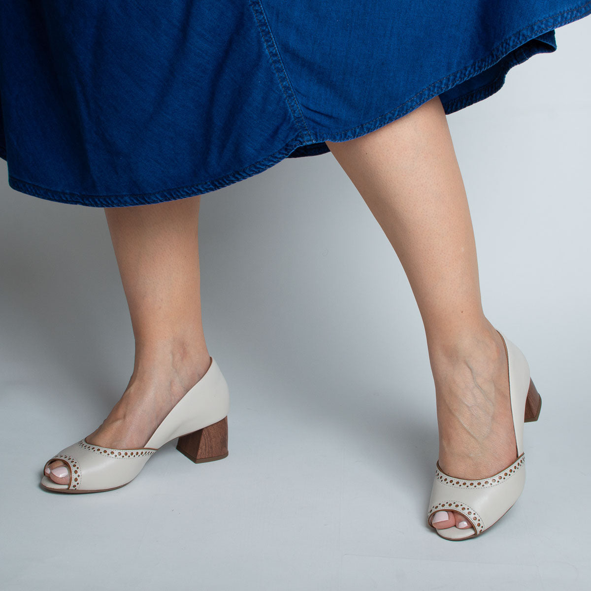 Woman wearing Urucum pumps with navy dress - lifestyle view