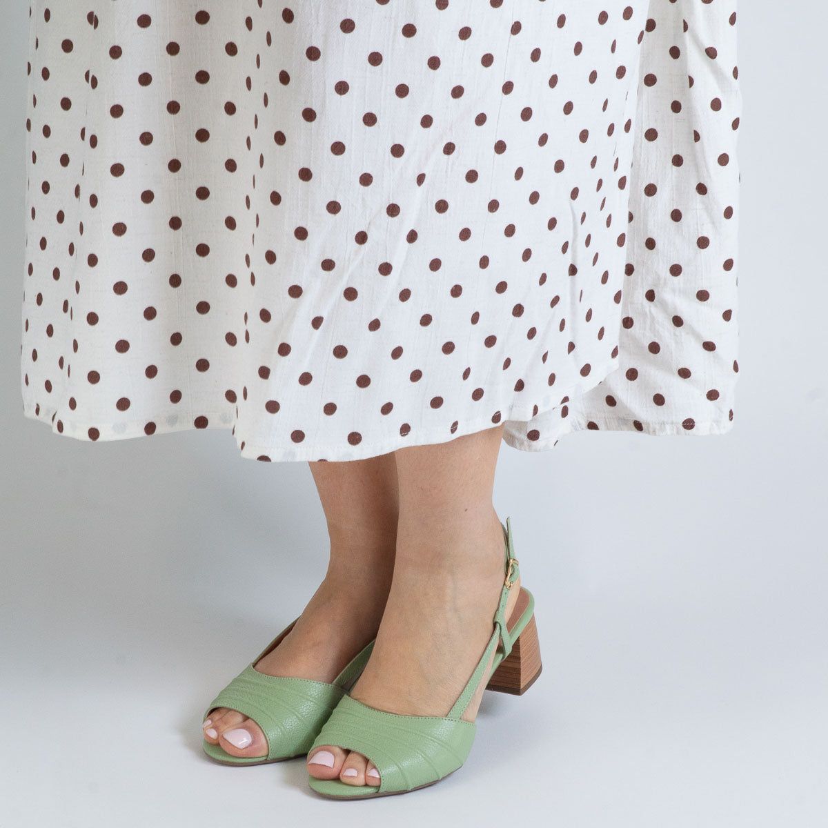 Woman's feet wearing Orquídea sandals with textured tights - lifestyle view