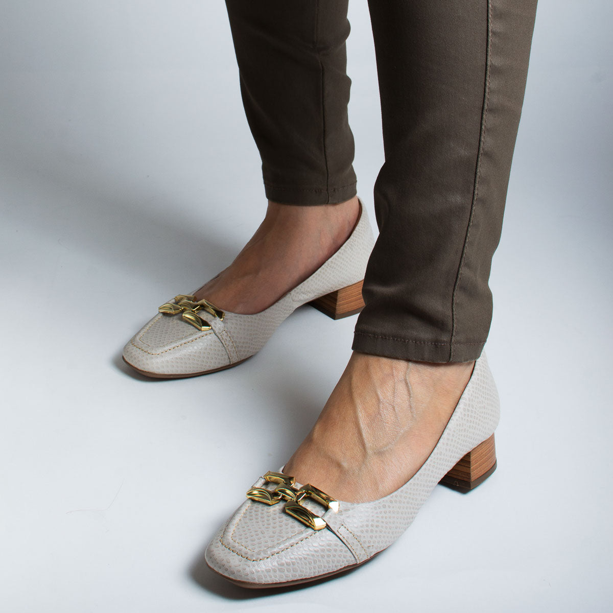 Woman wearing scale off-white Manjericão pumps with grey trousers - lifestyle view