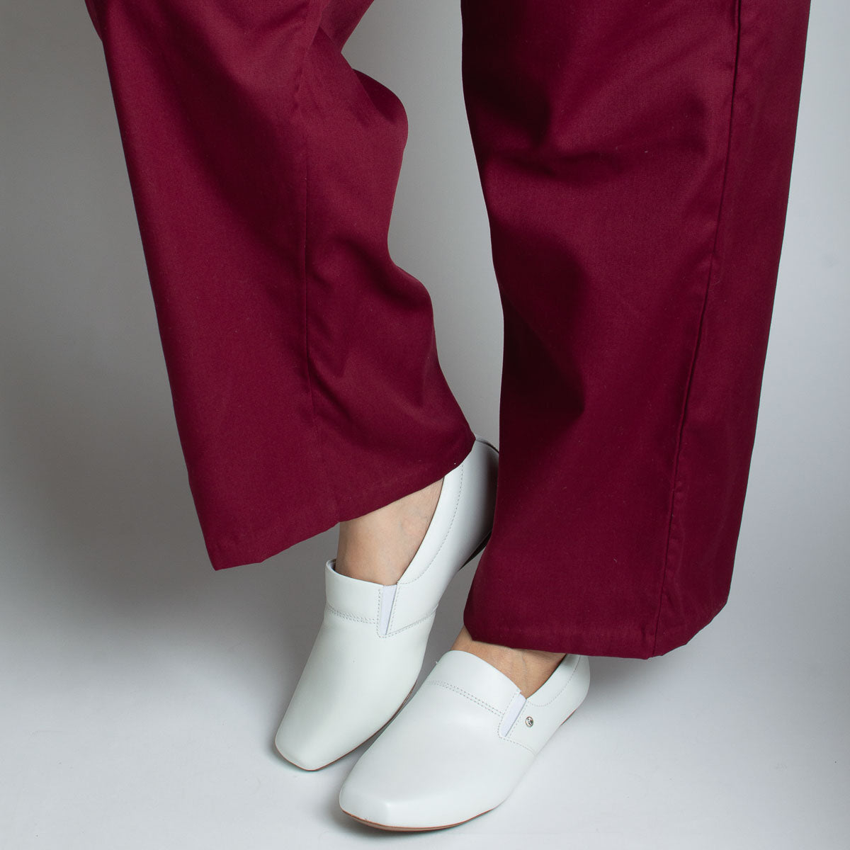 Woman wearing vegetal off-white Jacarandá shoes with burgundy trousers - lifestyle view