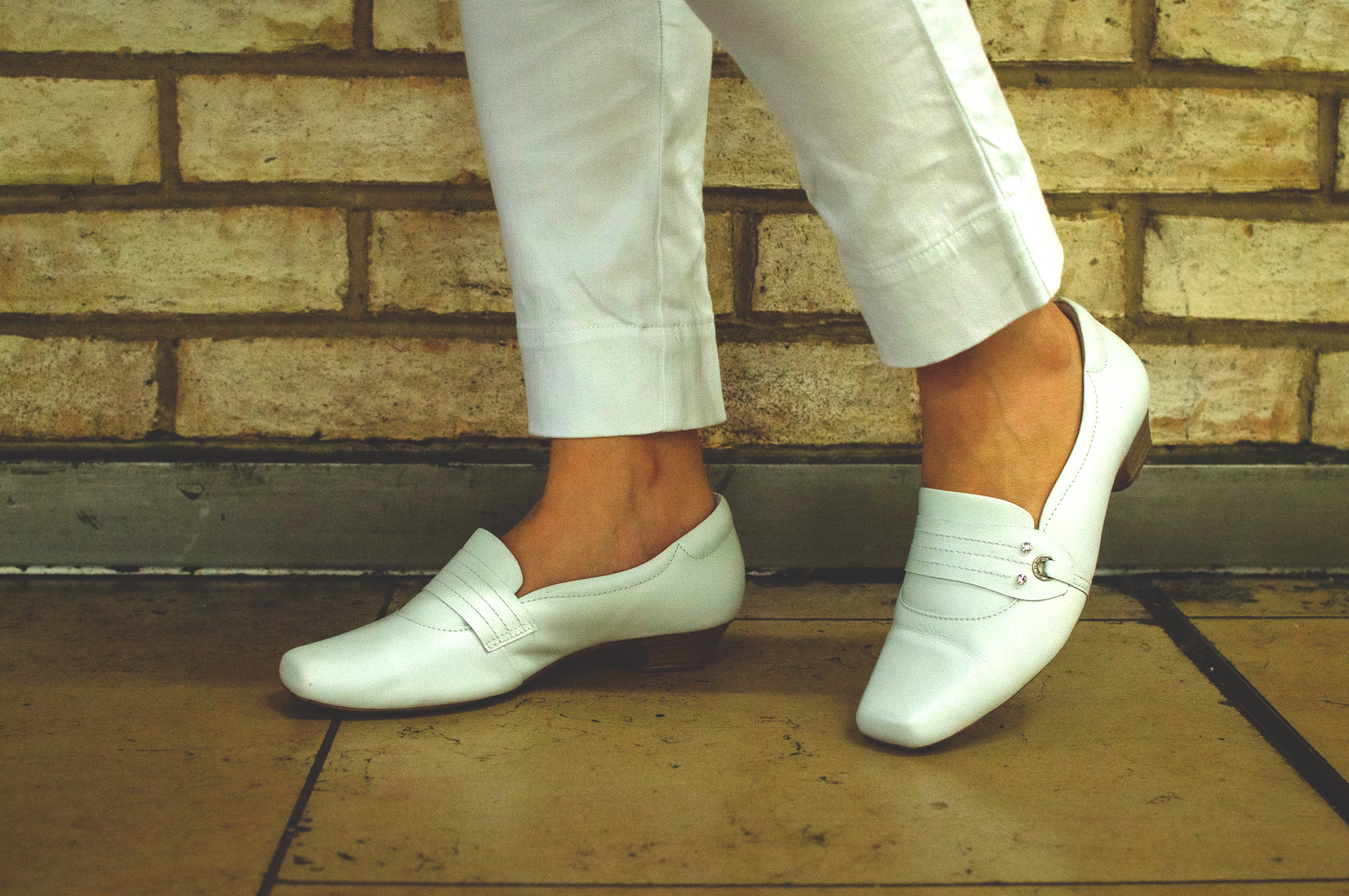 Woman's feet wearing comfortable Terraloom white shoes with cream trousers - lifestyle photography
