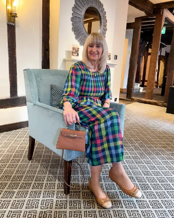 Woman wearing comfortable Terraloom shoes with colourful check dress and brown handbag - customer styling inspiration